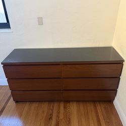 Wooden dresser with black glass top