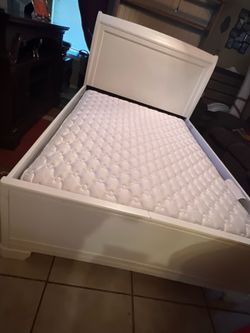 Full size white bed frame with mattress from Ashley’s
