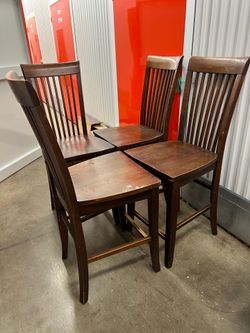 Brown rectangular wooden tall table and chairs.