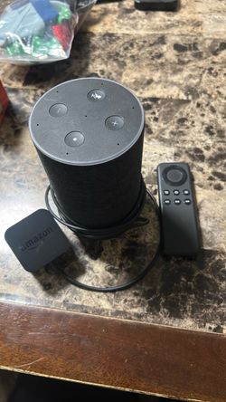 Amazon Echo 2nd or 3rd gen smart speaker with fabric exterior, plus an Amazon Fire TV Stick remote