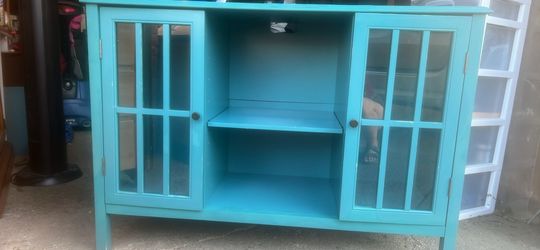 Teal media console with glass doors