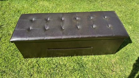 Brown faux leather folding storage stool.