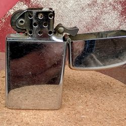 1970 Zippo Slim High Chrome Lighter (Good Working Condition). Has some visible wear and scratches.