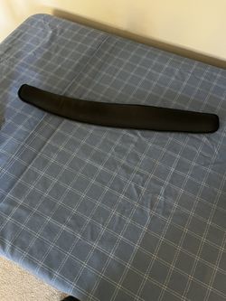 Black padded armrest for keyboard. 