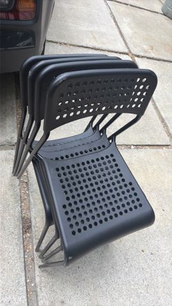 4 chairs  for 40 dollars all IKEA ADDE chairs in black, featuring a distinctive perforated plastic seat and backrest designed for stackable storage.
