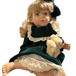 Doll porcelain 12” while sitting down in a velvet dress and her socks and shoes missing no original box or papers. T-91