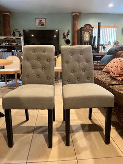 A pair of new Tufted, gray dining chairs