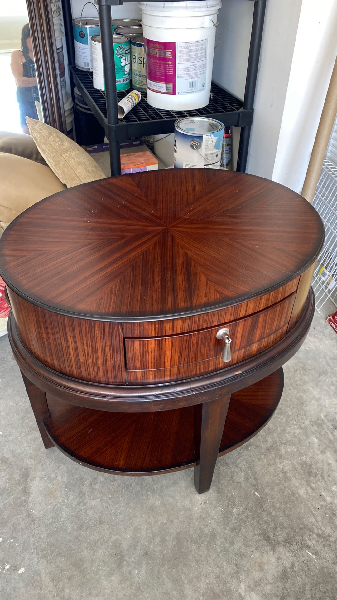 Oval side table with drawer and bottom shelf.