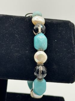 A multi - stone beaded  bracelet  featuring turquoise   Amazonite - style beads  while pearl