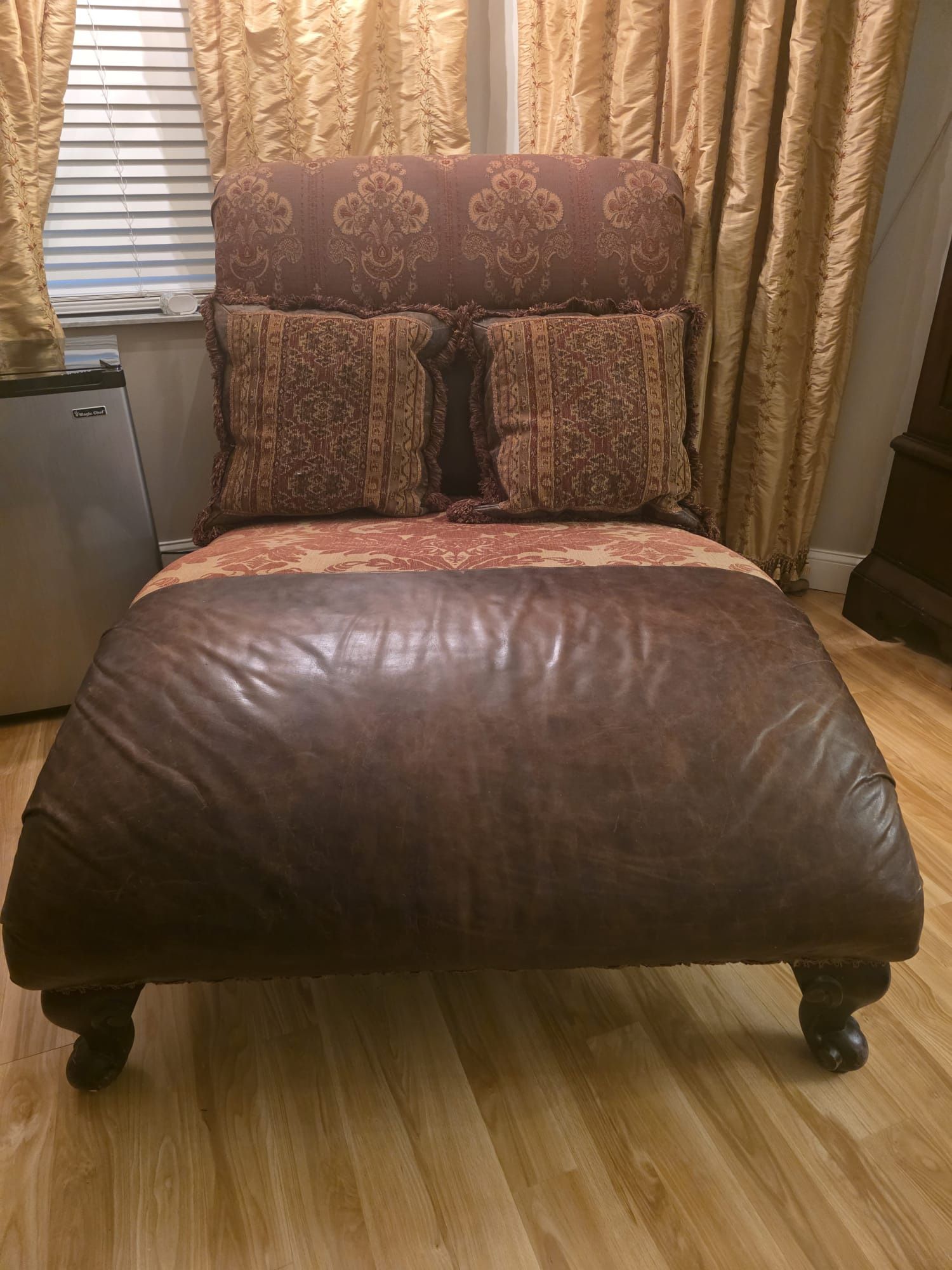 Brown leather and patterned fabric chaise lounge chair.