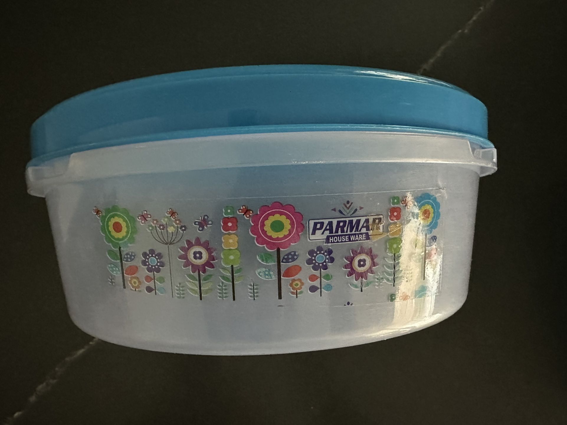 Clear plastic round storage containers with red, blue or pink lids.