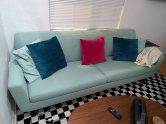 Mint sofa with teal red yellow cushions