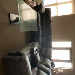 Dark grey sectional couch with recliners on both ends.