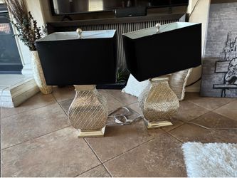 Two lamps with shades two wall pictures and a full-size white throw rug