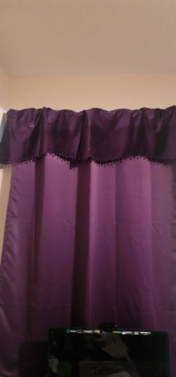 Purple curtains and matching rugs and flowers