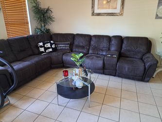 charcoal faux-leather/fabric reclining sectional sofa with a central storage console and built-in cup holders