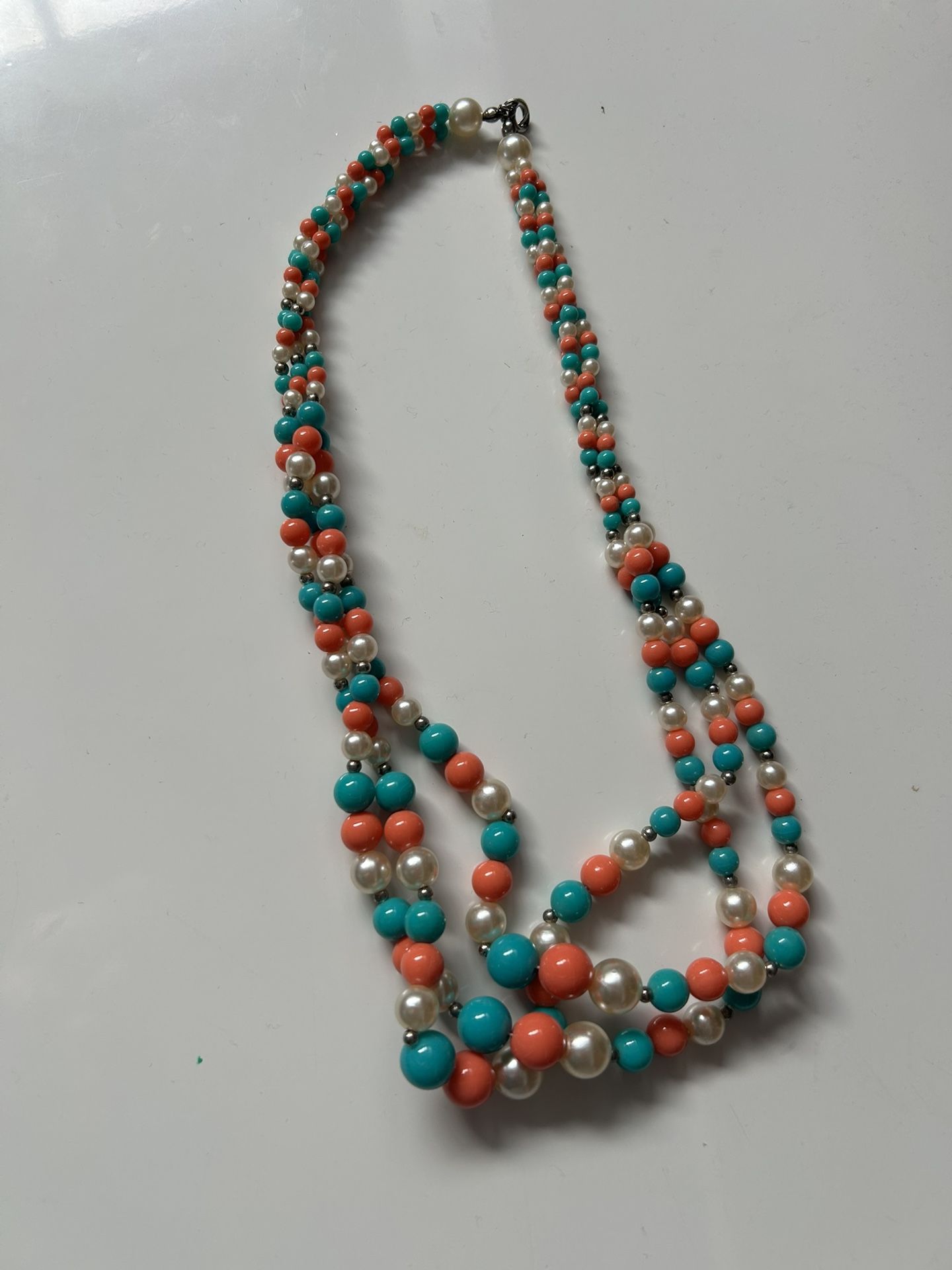 multi-strand beaded necklace featuring faux pearls, and beads colored to resemble coral and turquoise