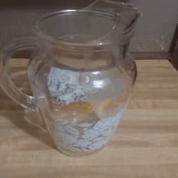 clear glass pitcher decorated with a white rose and gold floral pattern, often associated with vintage glassware