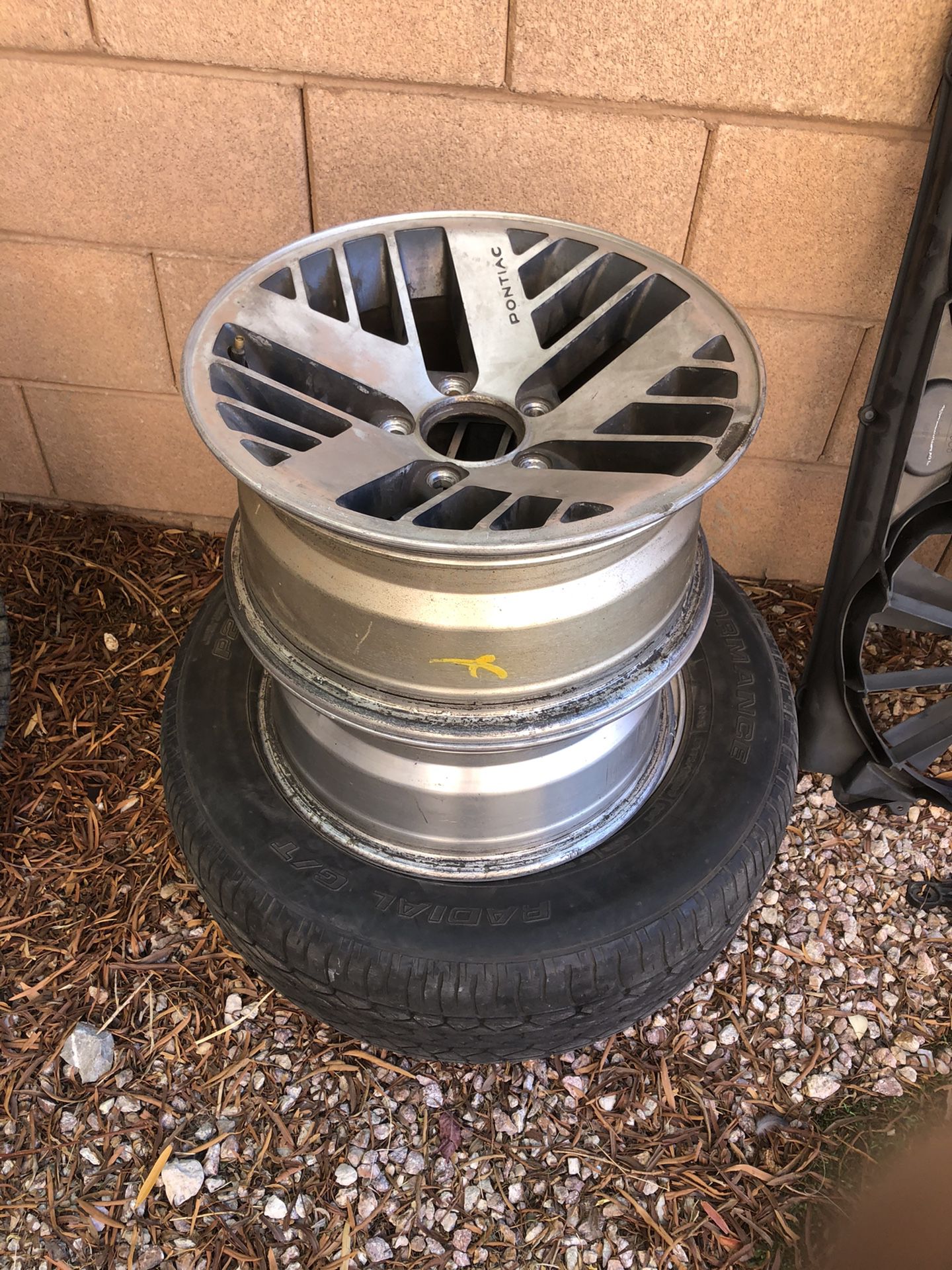 3 pontiac wheels with one tire