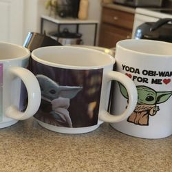 Collection of themed coffee mugs including Boston, LOL, and Yoda designs.