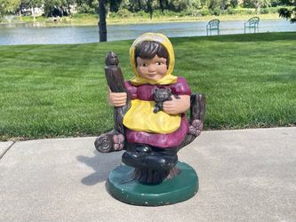 Concrete Girl Wearing Holding A Small Animal Perched On A Log