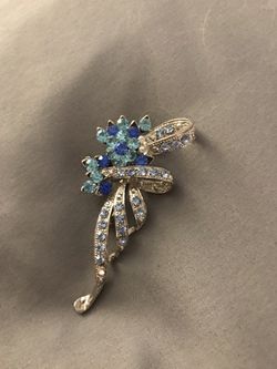 Beautiful silver broach incrusted with blue topaz and diamond rhinestones.