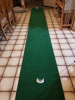 New golf mat putt about 15 feet long in the box. with 2 velcro potting disks