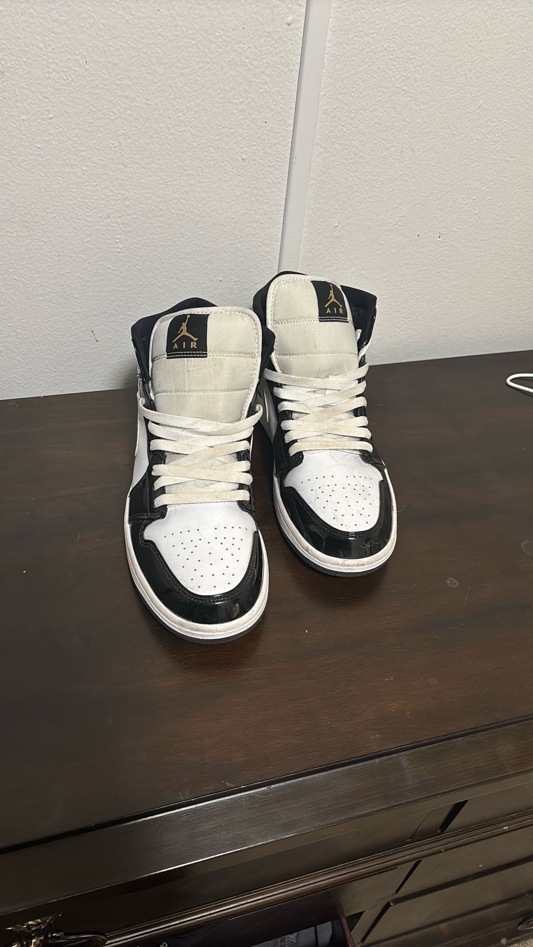 Air Jordan 1 Mid SE Patent Black White Gold sneakers.
