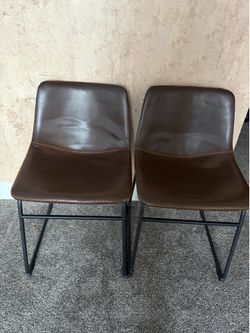 A pair of brown leather chairs