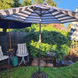 New 9' umbrella with crank and tilt mode in black and white with cast iron base. 