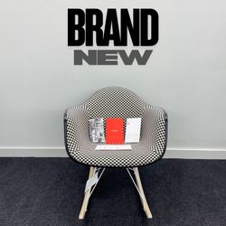 BRAND NEW HERMAN MILLER EAMES UPHOLSTERED MOLDED PLASTIC ARMCHAIR, ROCKER BASE. BLACK/WHITE CHECKERED PATTERN