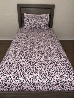 Twin bed with mattress and including comforter set and pillows