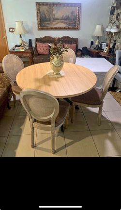 Vintage/classic dining set with a round wood-look table and four elegant cane-back chairs