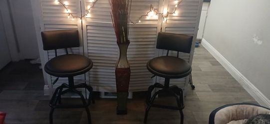 Two black swivel barstools