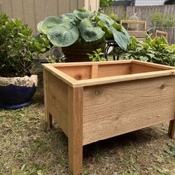  A container made of cedar wood designed for planting flowers & More.