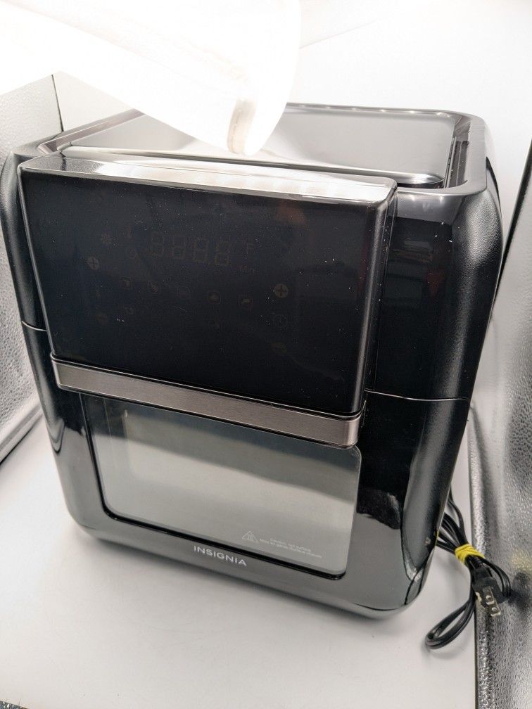 Insignia brand air fryer. The text on the image reads "Caution, hot surface" and "Mise en garde-Surface chaude," indicating the surface may become hot