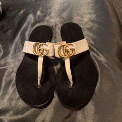 Gucci GG Marmont white leather thong sandals featuring an antiqued gold-toned Double G emblem