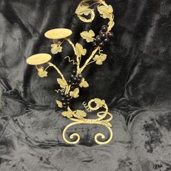 Candle holder decorated with grapes and vines and leaves