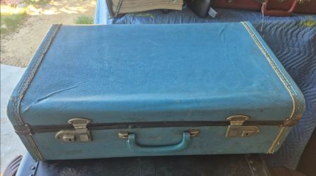 mid-century light blue vinyl-wrapped suitcase with metal latches molded handel . From panorama city