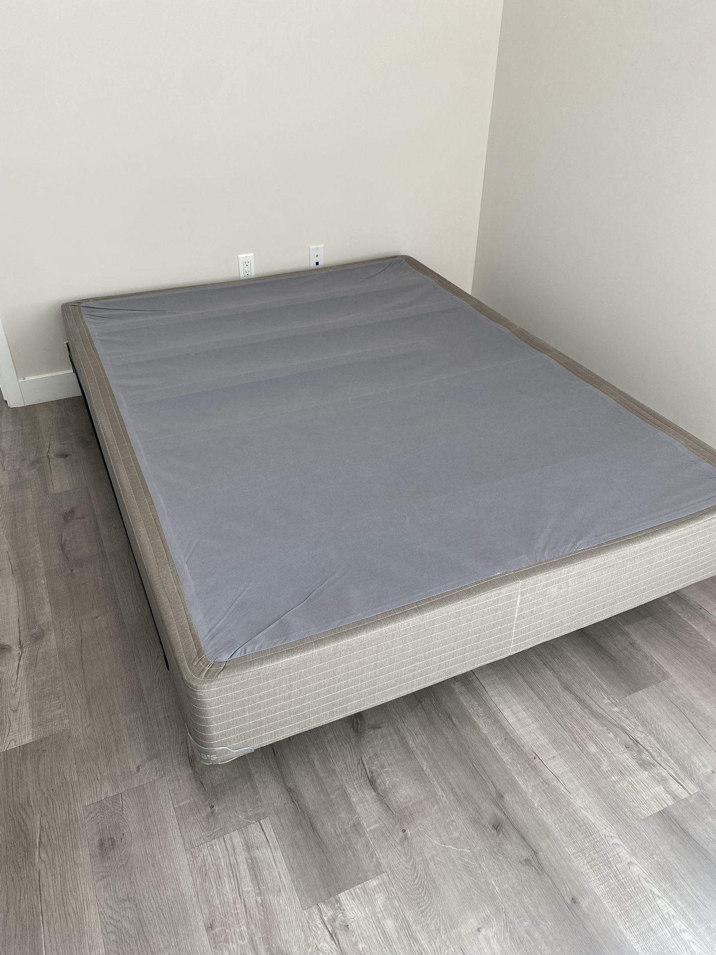 Queen -sized box spring and metal frame with casters.
