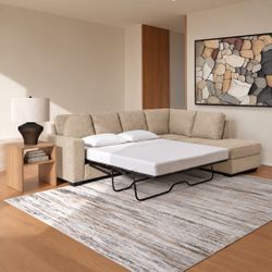 Sofá seccional de tela beige y cama incorporada
