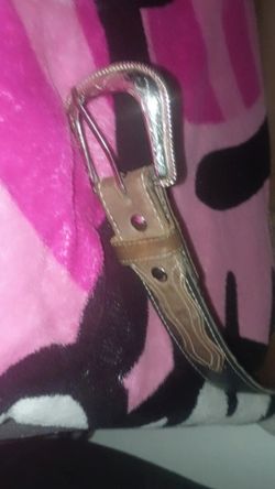 brown leather western belt featuring an ornate, engraved silver-tone buckle