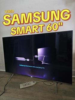 Large 60-inch 4K Smart TV is a Samsung Series 8 model. This black television has a slim bezel and silver-toned V-shaped legs. It requires a One Connec