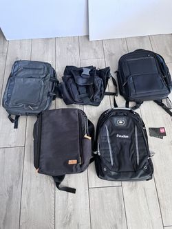 There are several black backpacks, including an OGIO brand model with the "stadion" logo printed on it. 