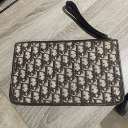 Oblique clutch bag with a brown logo on a beige background - Christian Dior logo