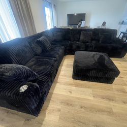 Large Black Sectional With Soft Fur Like Corduroy Fabric And Large Ottoman