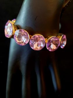 Two beautiful rhinestone bracelets. The clear rhinestone bracelet is a bangle bracelet. The purple rhinestone bracelet is a stretch bracelet.