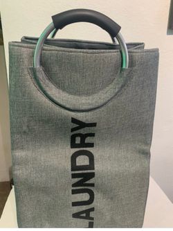 Grey laundry basket with metal handles.