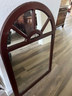 Decorative arched wall mirror with divided pane design and rich wood finish. Great for entryway, living room, or traditional décor. Sturdy and in good