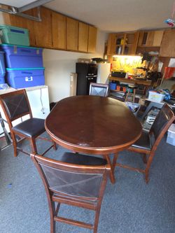 Counter high wood table with 4 leather back and seat chairs.